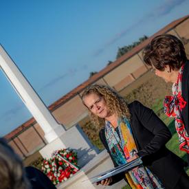 The Governor General delivers remarks from a podium at the Villanova Canadian War Cemetery.