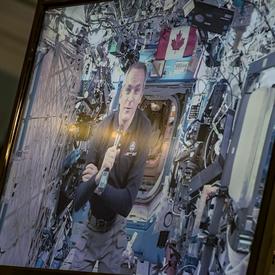 Canadian Space Agency astronaut David Saint-Jacques is on a television screen talking from the International Space Station. 