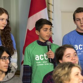 A young boy is asking Canadian Space Agency astronaut David Saint-Jacques a question. 