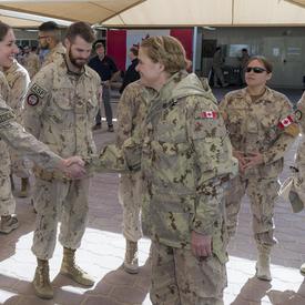 La gouverneure générale Julie Payette serre la main d'un membre des Forces armées canadiennes.