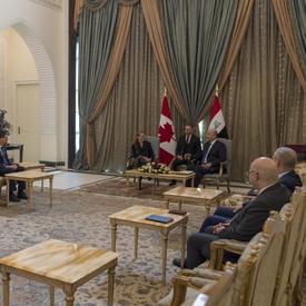 Governor General Julie Payette and His Excellency Barham Salih, President of Iraq are speaking to each other. An interpreter is sitting between them. Canadian and Irak officials are sitting on either side of the room. 