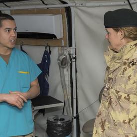 Governor General Julie Payette talks to a CAF member in medical gear. 