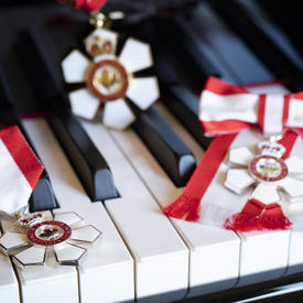 The insignia of the Order of Canada on the keyboard of a piano.
