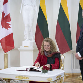 The Governor General signs the presidential guest book. 