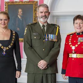 Luc Gagnon pose avec la gouverneure générale et la commissaire de la GRC Brenda Lucki.  Tous les trois portent leur insigne.  