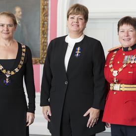 Ann King pose avec la gouverneure générale et la commissaire de la GRC Brenda Lucki.  Tous les trois portent leur insigne. 