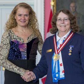 The Governor General is shaking Pat Watson’s hand. 