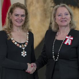 Agnes Di Leonardi se tient à côté de la Gouverneure générale.  Tous deux sourient à la caméra.  Elles portent leur insigne de l'Ordre du Canada.
