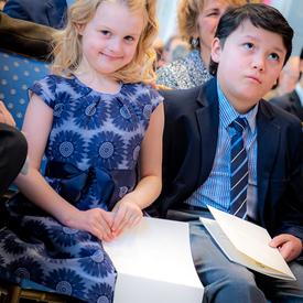Children sitting in the audience. 