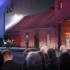 Une survivante parle à partir d'un podium. 