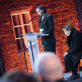 Une survivante parle à partir d'un podium. 