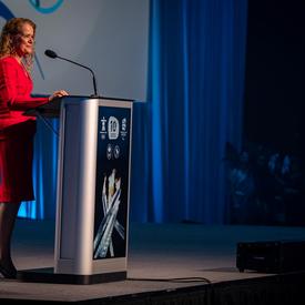 La gouverneure générale prononce une allocution sur un podium.