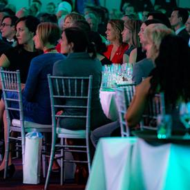 La gouverneure générale s'assoit à une table avec des invités lors d'un gala.