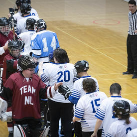 Two teams line up to shake hands after a hard-fought game. 