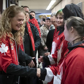 Vêtu de rouge Canada, la gouverneure générale serre la main des athlètes des Jeux olympiques spéciaux après leur match.