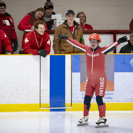 Un patineur de vitesse lève les bras et se prépare à participer aux Jeux olympiques spéciaux.