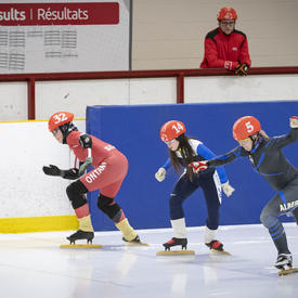 Athletes compete in a tight speed skating race.