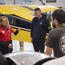 The Governor General in the Aviation Centre of Excellence hangar with students, teachers and aircraft.
