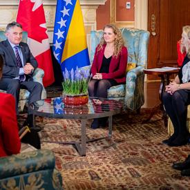  Canadian government officials and members of the Bosnia and Herzegovina delegation attend a meeting with the Governor General and His Excellency Željko Komšić. Everyone is sitting in chairs. 