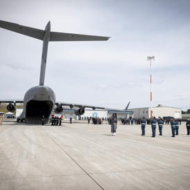 Une image d'ensemble des membres des FAC portant un cercueil au corbillard.
