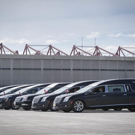  Six corbillards sont garés l'un à côté de l'autre. 