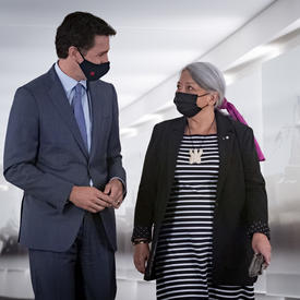 1.	Prime Minister Justin Trudeau and Governor General Designate Mary May Simon look at each other as they walk side-by-side down a hall..