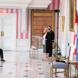 Governor General Mary May Simon stands at a podium addressing a crowd.