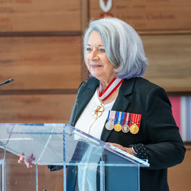 La gouverneure générale Mary May Simon debout derrière le lutrin s’adresse au public.