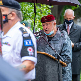 A veteran speaks at a podium.