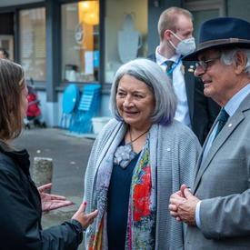 Their Excellencies are speaking with a woman on a street in Old Town Frankfurt. The Governor General is smiling. 