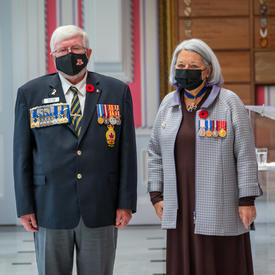 La gouverneure générale Mary May Simon et M. Bruce Julian sont debout l’un à côté de l’autre dans la salle de la tente à Rideau Hall. M. Julian est à la droite de la gouverneure générale. 