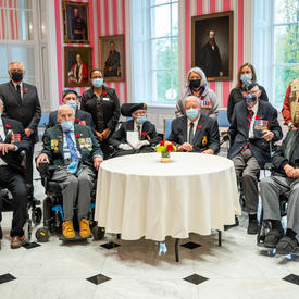  Leurs Excellences sont photographiées avec des anciens combattants canadiens. Tous les anciens combattants sont en uniforme. Ils sont dans la salle de la tente.