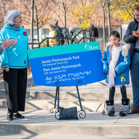 The Governor General and a young girl stand with the sign for the Annie Pootoogook Park between them.