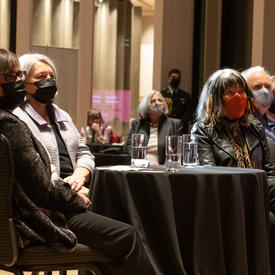 Audience, including Governor General Mary Simon and Buffy Sainte-Marie, sitting at a table.