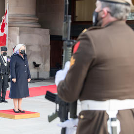The Governor General stands on a small red platform outside of the Senate.