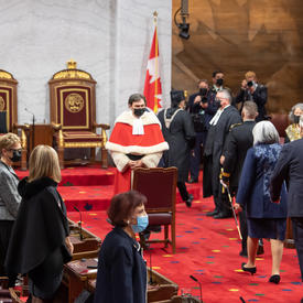 Un cortège, comprenant la gouverneure générale, entre au Sénat. Le juge en chef du Canada les regarde entrer.