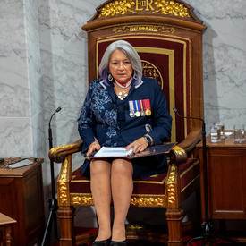 Governor General Mary Simon reads the Throne speech in the Senate. She is wearing a navy blue ensemble.