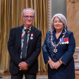 Michel Cusson is standing next to the Governor General.