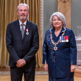 Robert Godin is standing next to the Governor General.