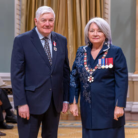 Stanley Hamilton is standing next to the Governor General.