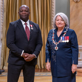 Robert Small is standing next to the Governor General.