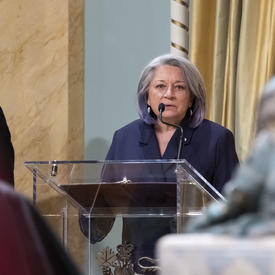 La gouverneure générale Mary Simon, debout sur un podium, s'adresse à une foule.