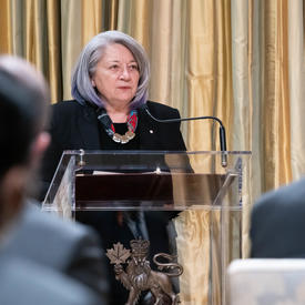 La gouverneure générale Mary Simon, debout sur un podium, s'adresse au public.