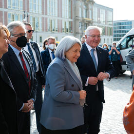 Her Excellency and a group of people outdoors wearing masks.