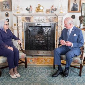 His Royal Highness The Prince of Wales and Governor General Mary Simon are sitting across from each other in a room at Clarence House. 