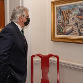 Mr. Whit Fraser looking at a painting on display at the Canada Gallery.