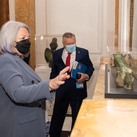 La gouverneure générale Mary Simon regarde un objet exposé à la Maison du Canada.