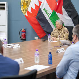 The Governor General is seated at a large table at Canada Camp. 