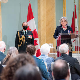 La gouverneure générale, debout sur un podium, s’adresse à la salle pendant la cérémonie de remise de la Médaille du souverain pour les bénévoles