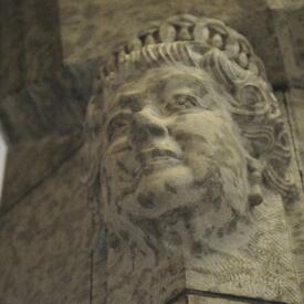 Bust of The Queen carved in stone on the side of a pillar. 